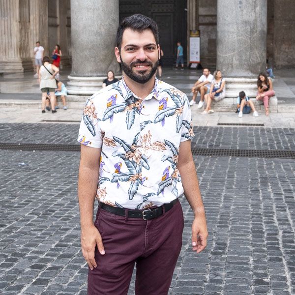 Photo of Jacob in casual clothes standing in an Italian piazza.